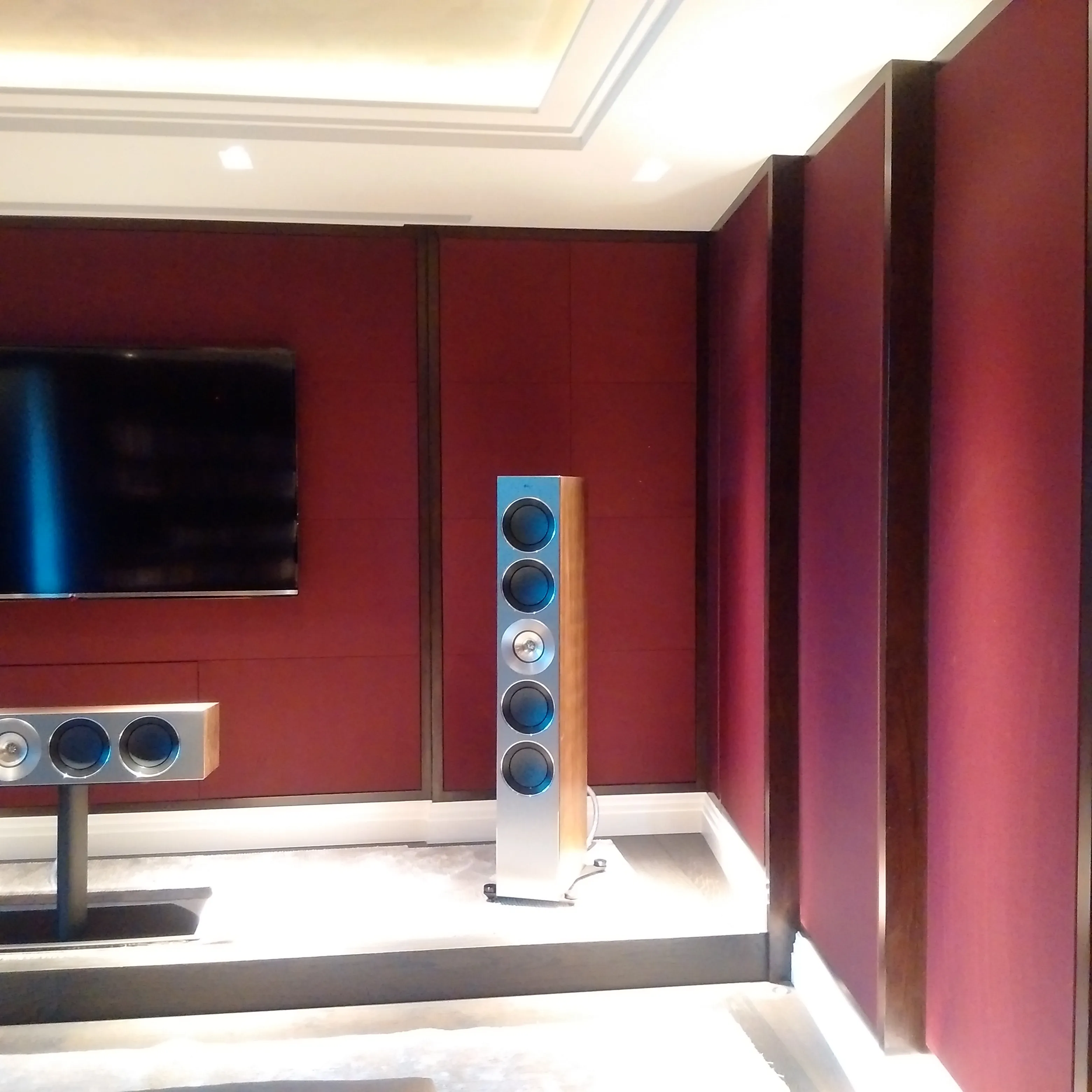 Sleek sound system setup with a wall-mounted TV and floor-standing speakers in a modern room