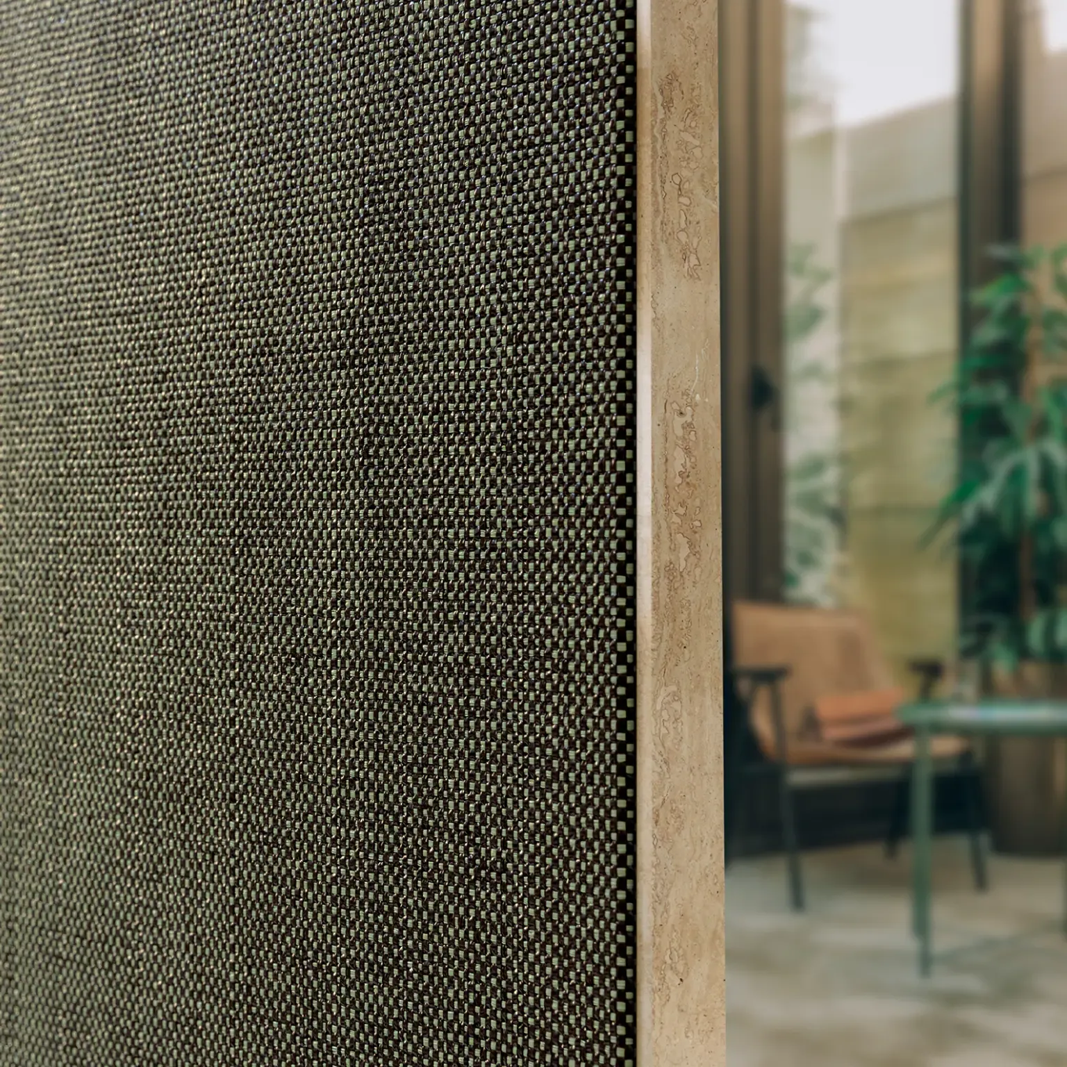 Close-up of a textured stretch-fabric wall panel beside a refined dining interior